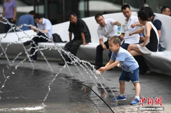 资料图：6月16日，一儿童在北京银河soho戏水玩耍。中新社记者 崔楠 摄