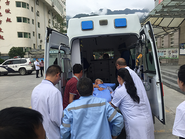 院长和医务人员把乔大帅送上救护车,转移至成都继续治疗.