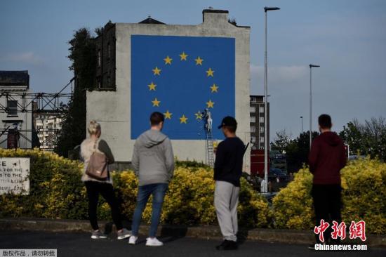 资料图：英国街头艺术家班克西创作了一幅画，画面中一名工人正从欧盟12星旗帜上抹掉一颗星，寓意着英国将脱离欧盟。