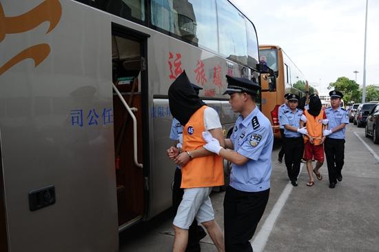 7月6日,民警在长沙黄花国际机场押解犯罪嫌疑人.新华社记者 谭畅/摄