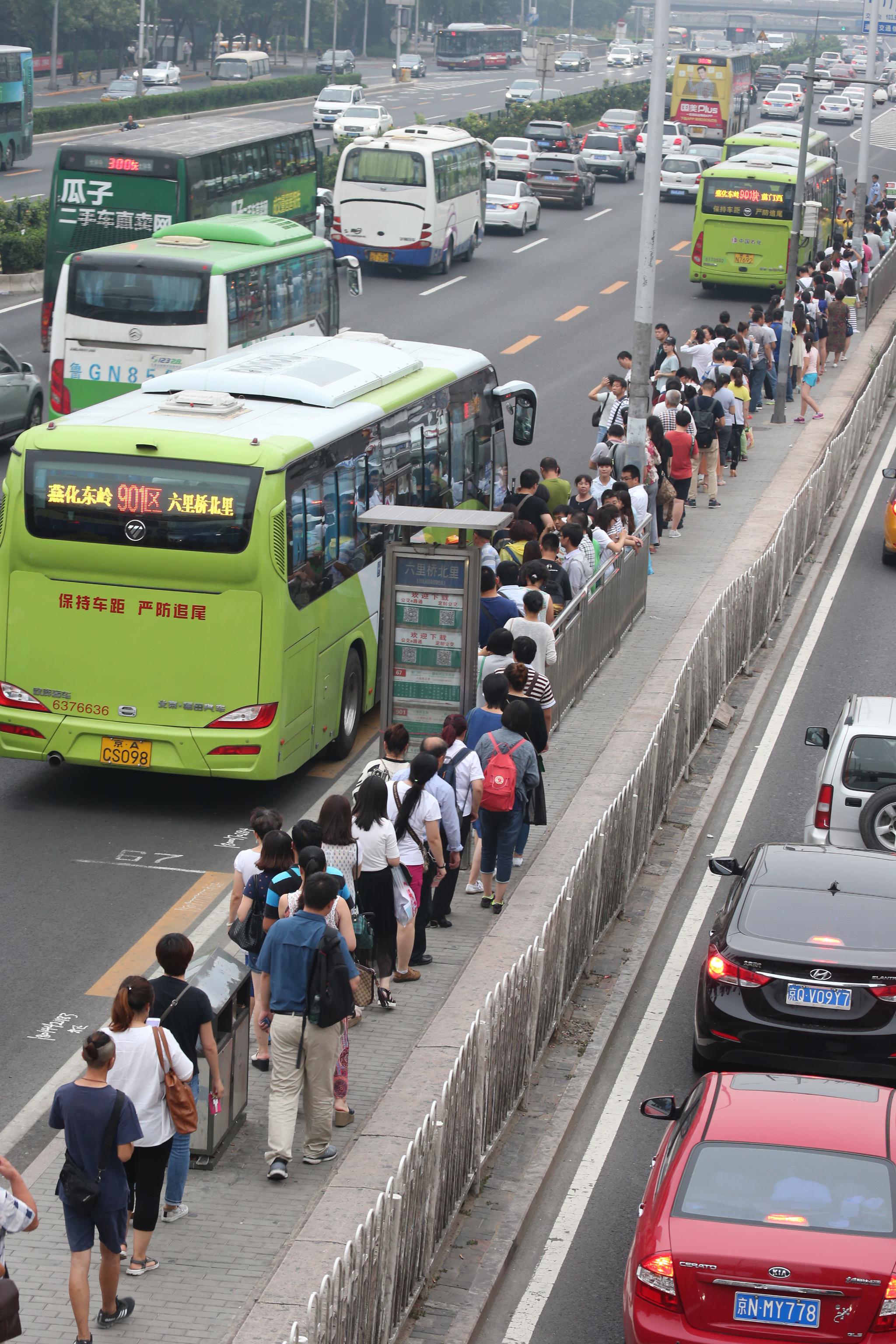 7月20日下午17点30分,六里桥北公交车站,引导员在维持秩序  唐盛时摄