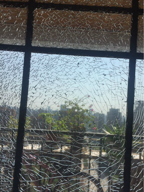 然而却发现家中阳台的玻璃门炸裂得不成样子,小王对此已经无法言语.