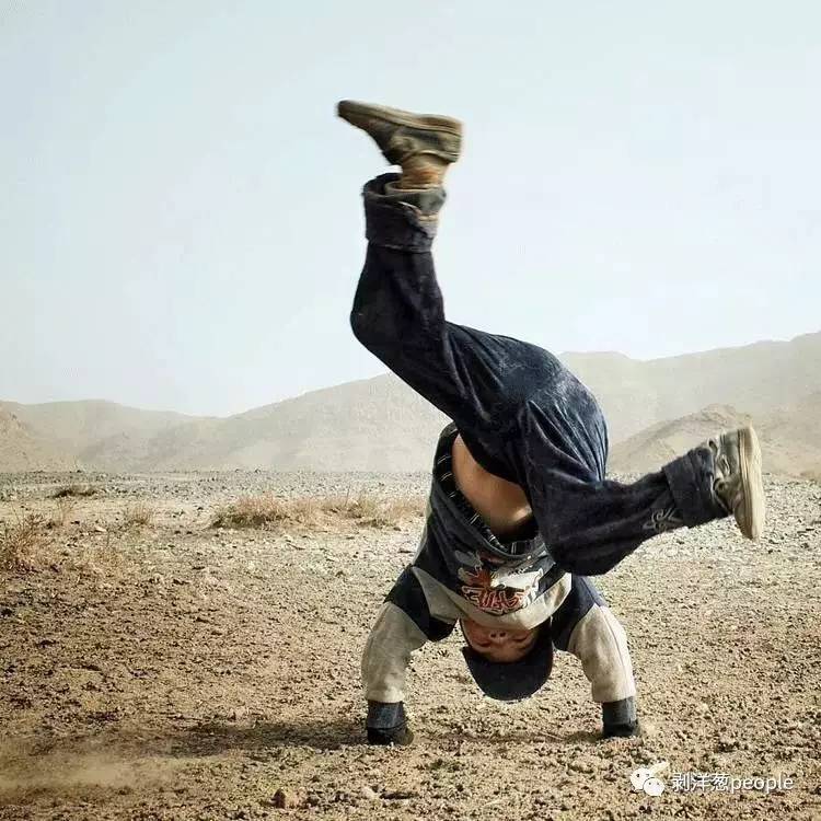 一名儿童在空旷的土地上翻跟头,尽情玩耍.新疆民间制陶人.