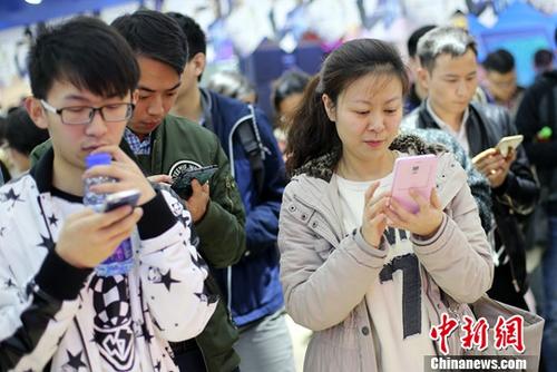 资料图：民众使用手机参加网络互动游戏。中新社记者 泱波 摄