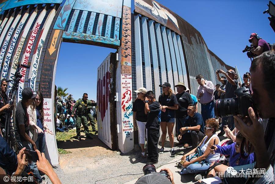 今年4月，美国边境巡逻队暂时开放美墨边境墙，居住在两边的亲人们得以短暂团聚 （图/中国日报）