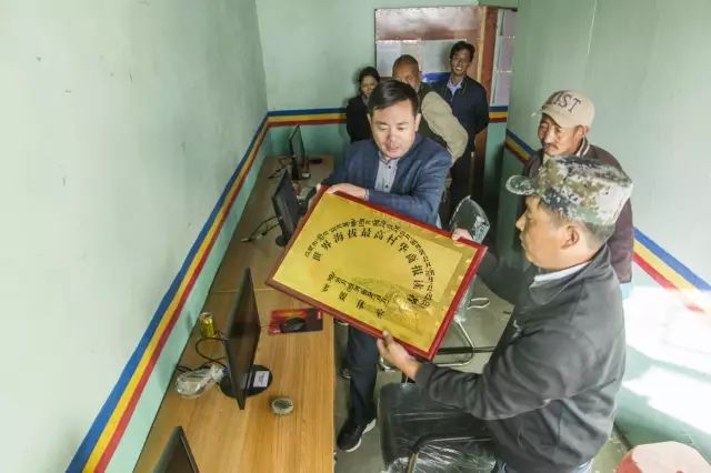 捐助人士桂志明先生和强巴次仁书记一起将"世界海拔最高村华商报读者
