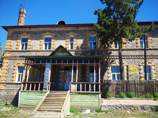 这座坚固的石头房子在周围低矮平房的衬托下很显眼.