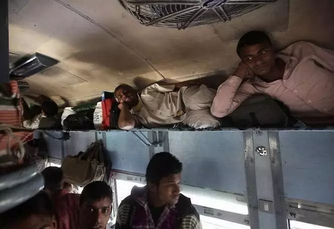 印度火车车厢往往十分拥挤,所有的座位,架子,车厢间的连廊,甚至连厕所