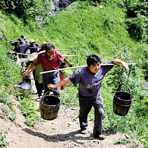 王光国(右一)和村民一起挑水抗旱. 杨顺丕摄(新华社发)