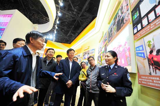 的五年"大型成就展上,公安部刑事侦查局打拐办副主任孟庆甜拿着手机