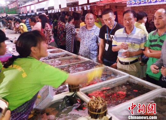 三亚海鲜宰客:三亚两家海鲜店因欺客宰客被实行“一次性死亡” 图为三亚某海鲜加工广场,前来购买海鲜的顾客络绎不绝。(资料图片,图文无关) 尹海明 摄