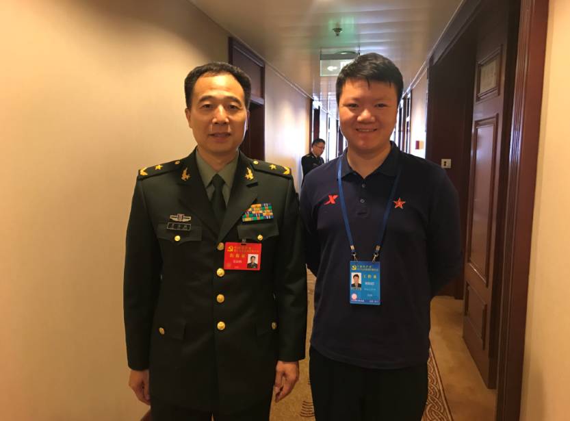 2017年10月,解放军报社记者欧阳浩(右)在参加党的十九大报道时,与航天
