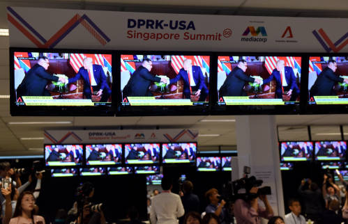 图为2018年6月12日，记者在新加坡的国际媒体中心观看朝美领导人会晤的直播画面。新华社