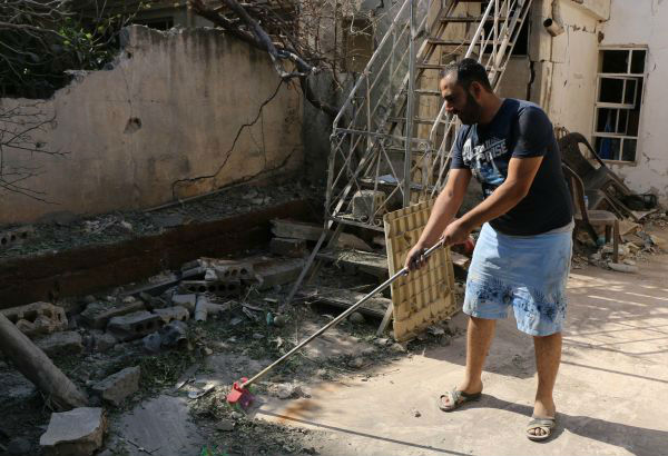 10月12日,叙利亚哈塞克省卡米什利,一名男子在清扫炮击后留下的碎石瓦砾。(新华社发)