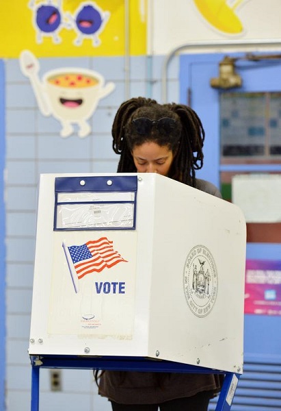 图说：11月6日，在美国纽约曼哈顿，一名选民在一处投票站填写选票。新华社