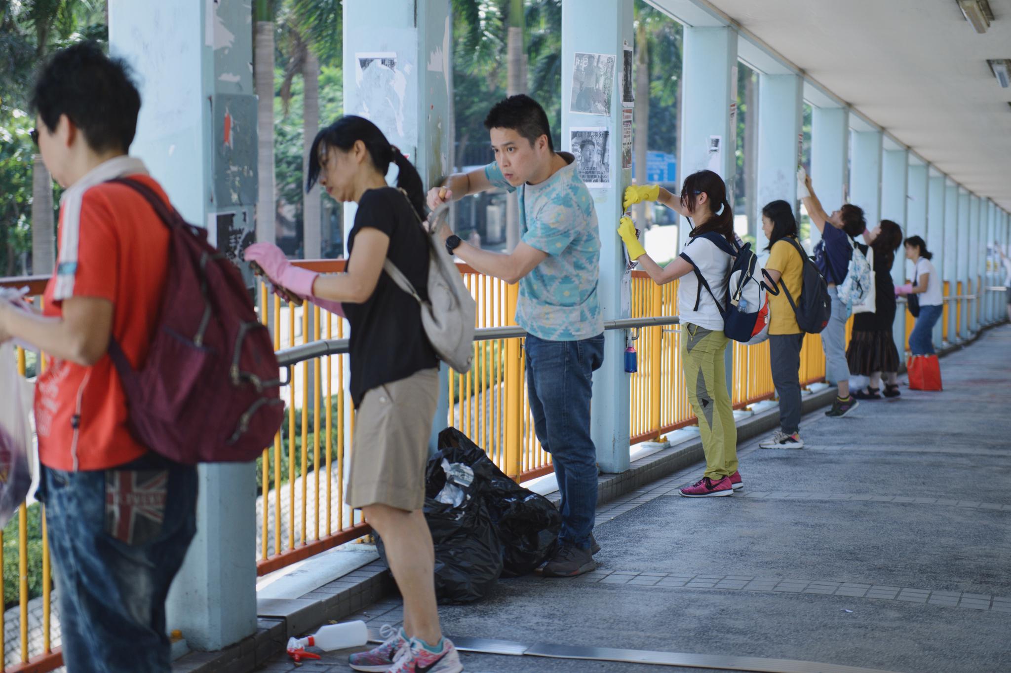 清洁队伍在红磡地铁站外天桥清理标语、海报和涂鸦。
