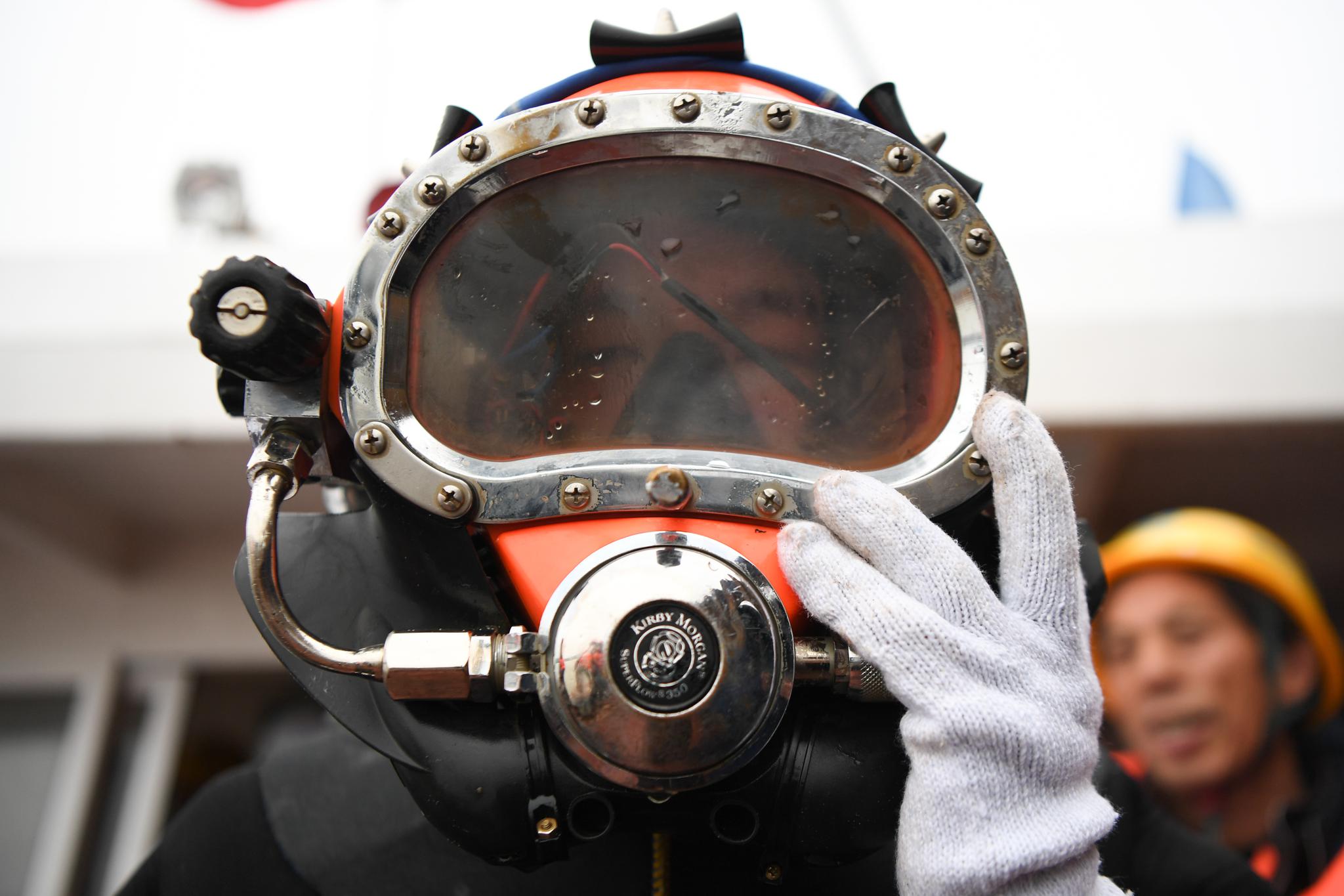 1月11日,伍转在下水前调整潜水头盔.新华社记者 薛宇舸 摄