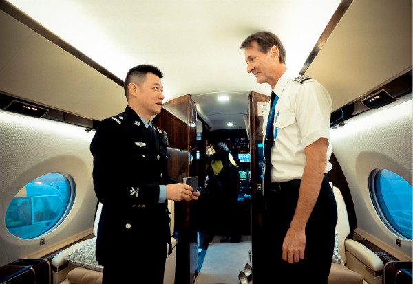 图说:上海边检民警在对公务机工作人员进行证件查验.