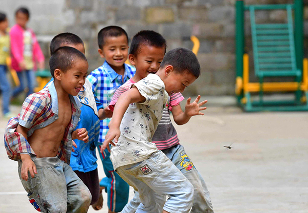 一所乡村学校内，孩子们在追逐蜻蜓。 黄孝邦 图