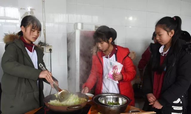 ▲这是蒿坝镇中心校女子篮球队队员蒋巧、罗绍丽和刘润（从左至右）在准备午饭（2018年12月8日摄）