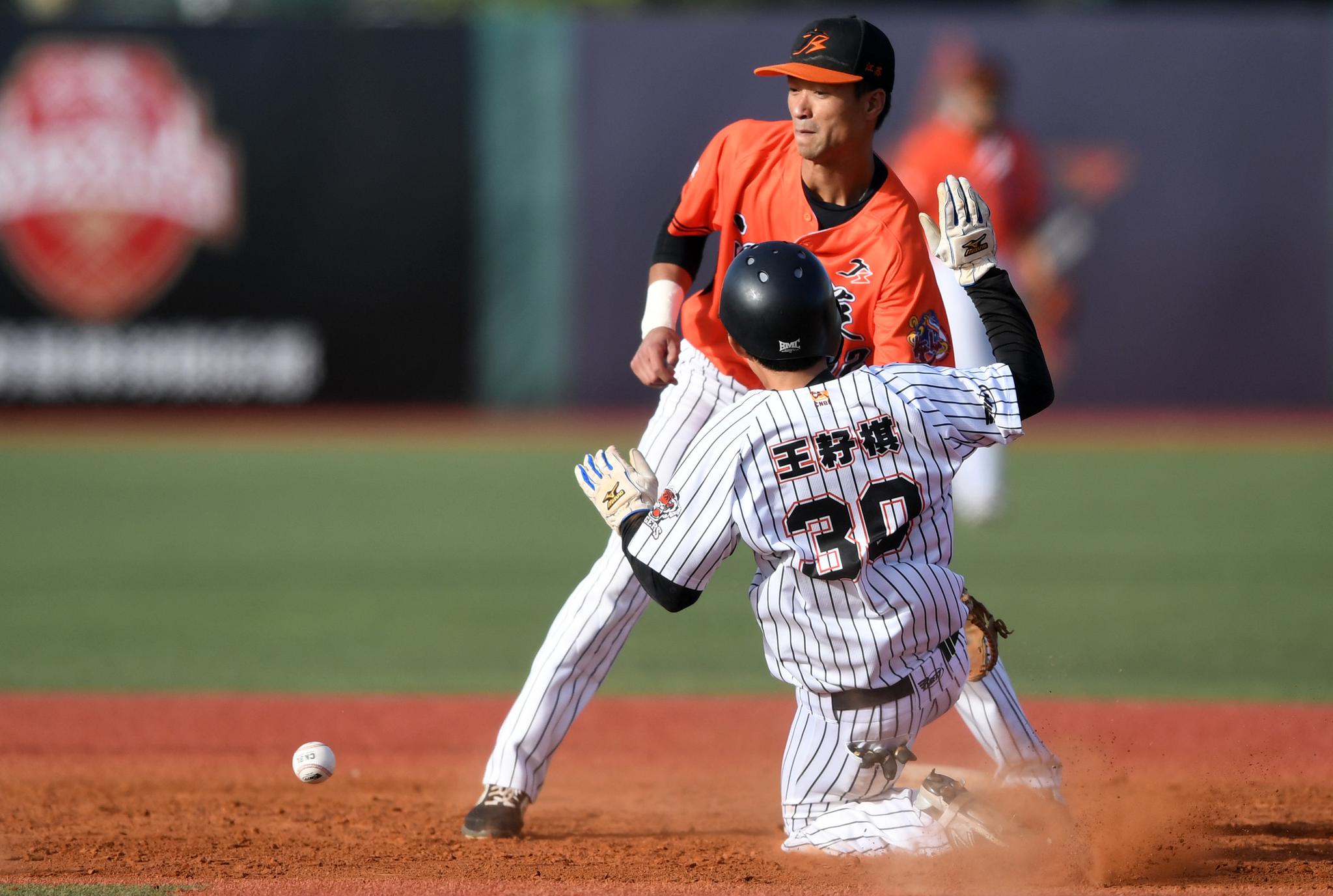 新华社记者李俊东摄↑北京猛虎队球员王耔棋(右)在比赛中上二垒成功