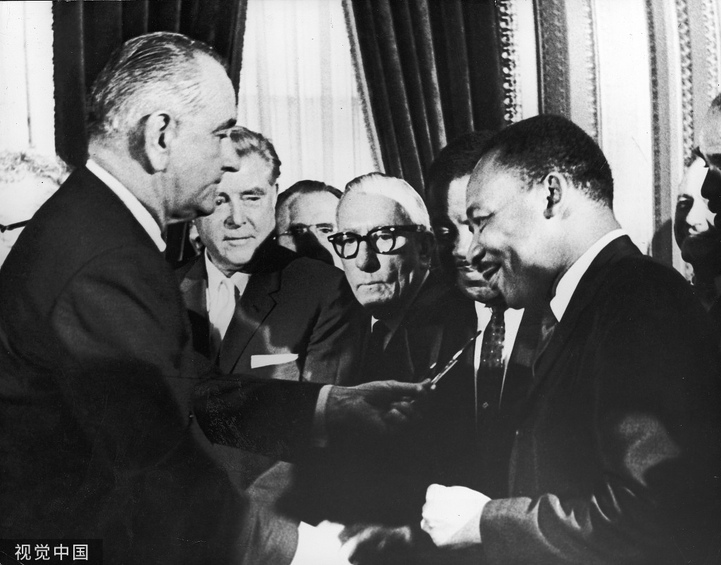 1965年，马丁·路德·金与约翰逊总统签署《选举权法》 图片来源：视觉中国