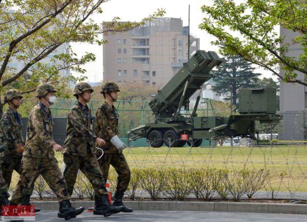 资料图：日本东京的防卫省总部，自卫队队员在“爱国者3型”导弹发射装置前走过。
