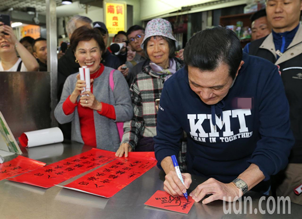 马英九（右一）今天跟大姐马以南（右三）到兴隆市场买菜，被摊商要求在春联上签名。（图片来源：台湾《联合报》）