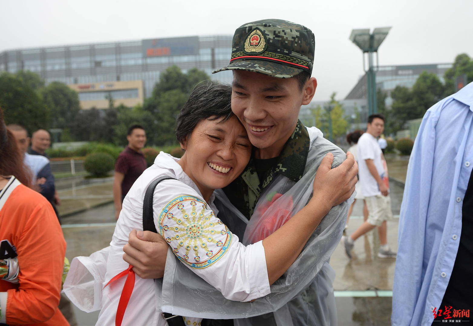 一位母亲拥抱送别新兵入伍的儿子住在部队大院,听着军号声长大,童年的