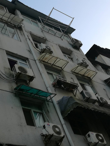 高楼老旧设施经历风雨摇摇欲坠社区排查防雨棚