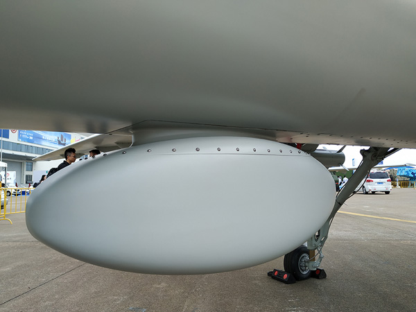 后起落架前方的机身下部安装了一个类似椭圆形的天线罩,里面可能安装