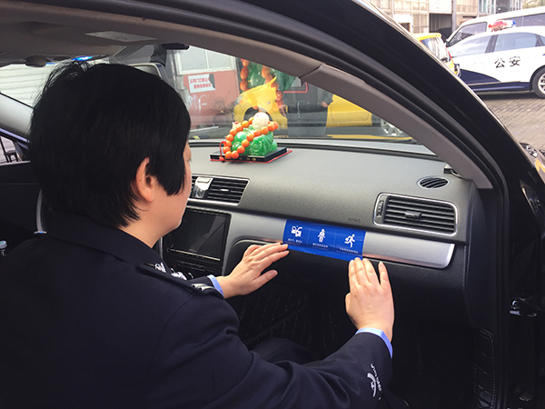 交警代表為車輛張貼安全行車標識。