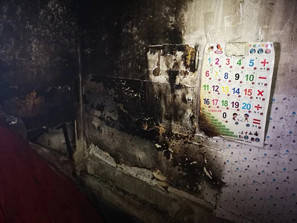 起火点集中在出租屋内床靠墙的一侧，墙面乌黑碳化。澎湃新闻记者 宋蒋萱 摄