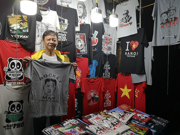  店铺前，老板Duc与他特制的“金特会”T恤。澎湃新闻记者 辛恩波 李佩 图