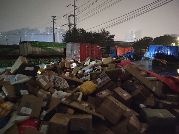 11月17日,百世快递大量包裹被堆放在露天工地。