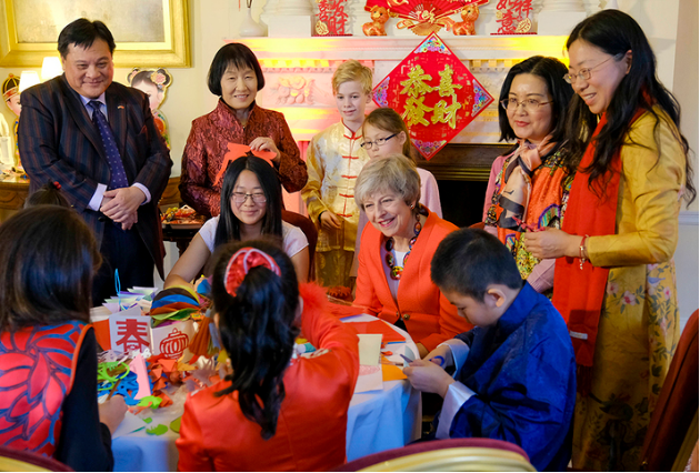  身着红装的梅特意和孩子们单独合影。图自英国首相府官方网站