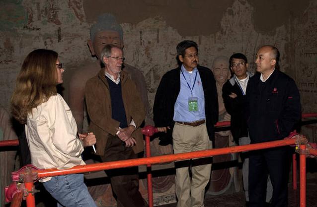 王旭东与外国同行一起研究工作。资料图/敦煌研究院官网