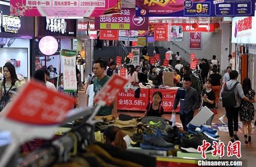　　图为市民在一商场内选购打折商品。（资料图片）中新社记者 张斌 摄