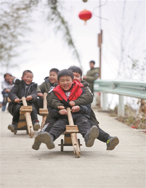 2月9日的贵州北西苗寨,孩子们参加传统木板车体验.