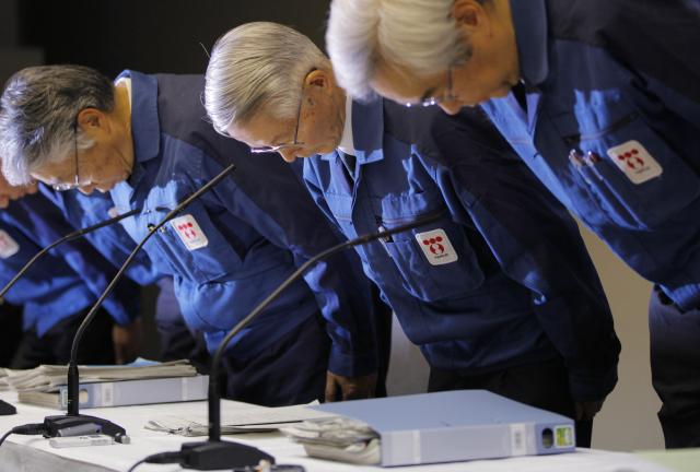 2011年3月30日，东电前高管胜俣恒久（中）、武藤荣（右）在东京出席新闻发布会前鞠躬。（新华社/美联）