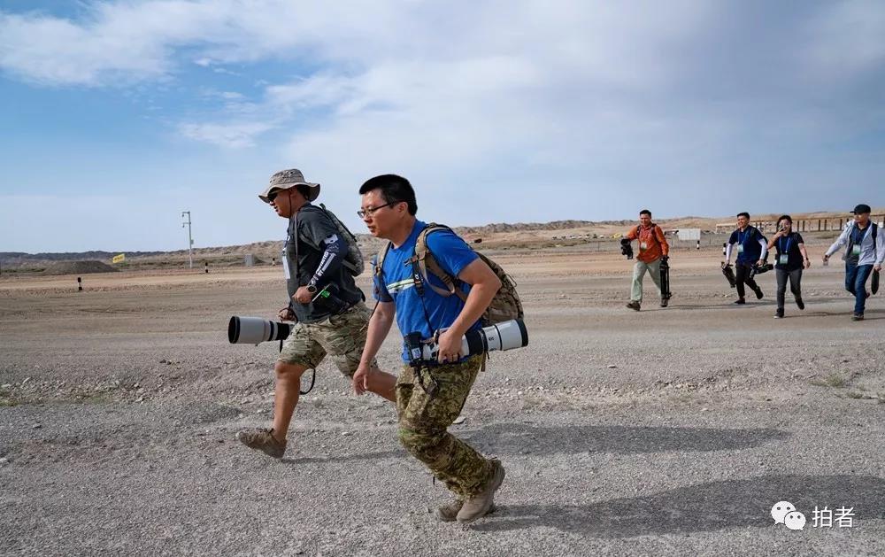  △ 2019年8月4日，新疆库尔勒，环球时报记者崔萌（左）和人民画报记者万全（右）在拍摄国际军事比赛的路上奔跑。摄影/新京报记者陶冉