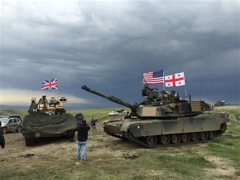 图为北约联合军演中的美军M1A2坦克与英军战车合影。