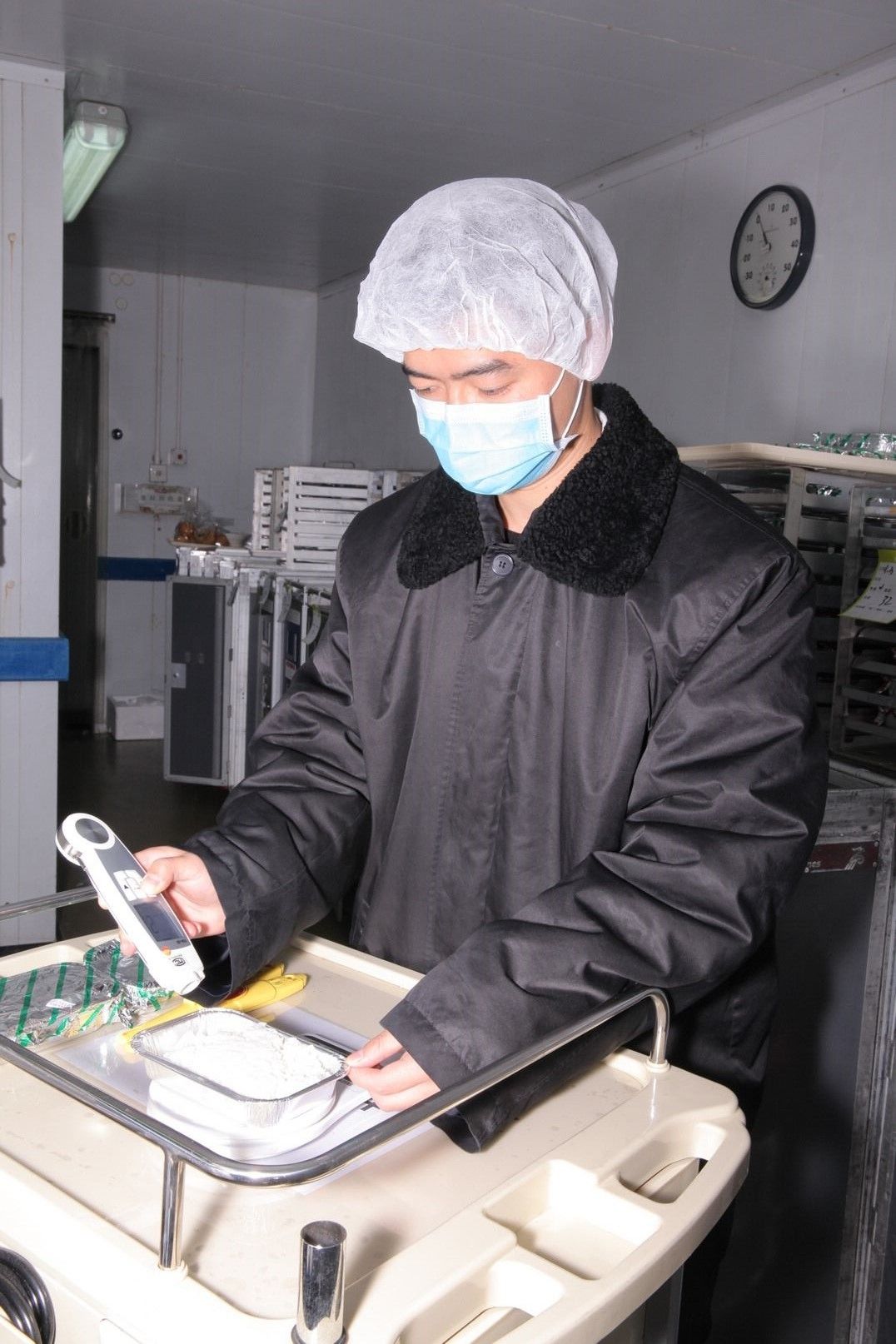 图:在0℃低温冷库车间内质检员对航空餐进行出厂检验成品温度检测
