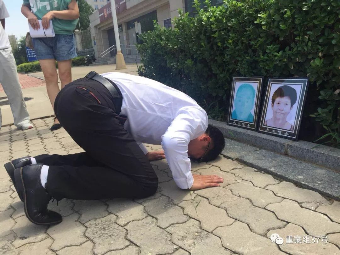 获无罪后,廖海军在法院门前朝父母遗像磕头告慰.