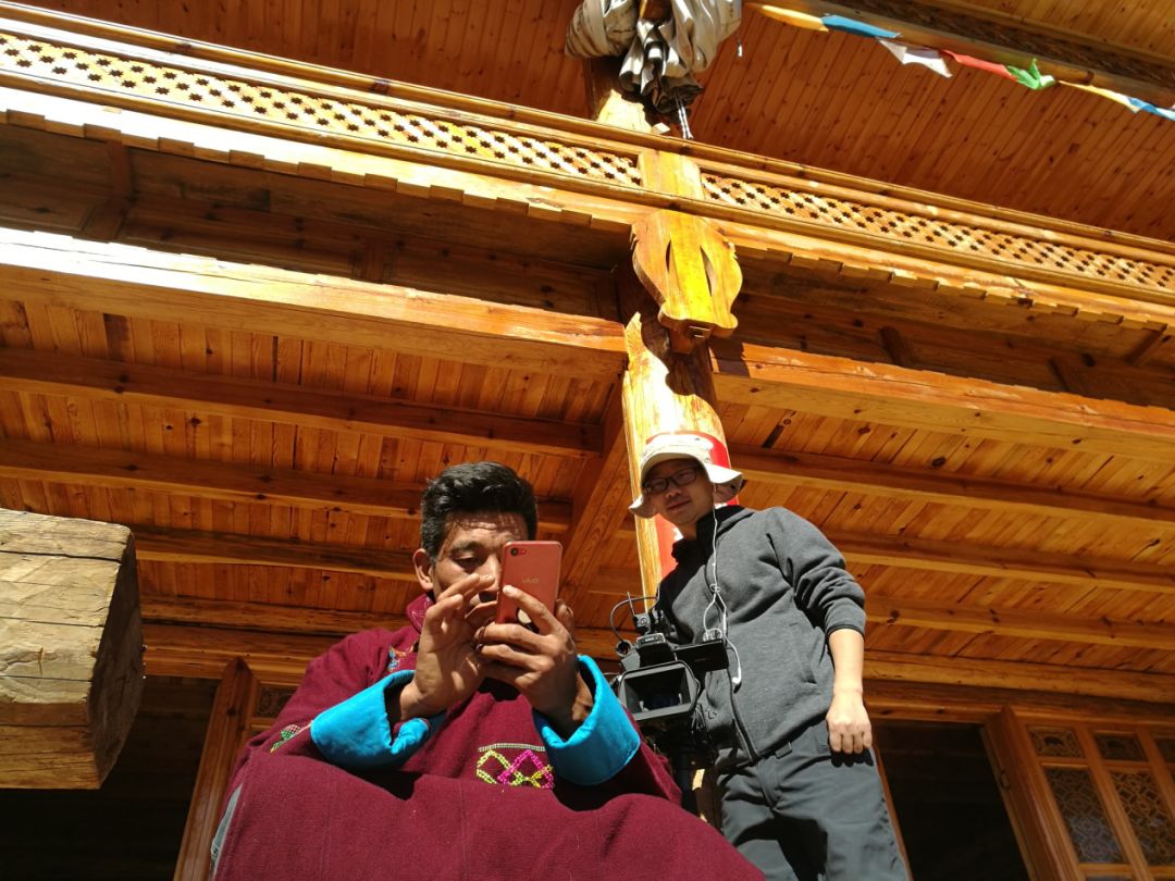 木里县利家咀村村民杜基在自家旅游驿站前使用手机与远在千里之外的