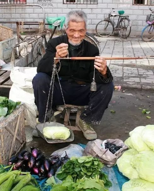 一把杆秤,几种小菜一根扁担,两个箩筐卖菜的老人总会依时"登场"还是像