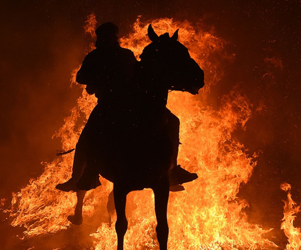 西班牙小镇居民骑马过火海庆祝节日 场景如世界末日