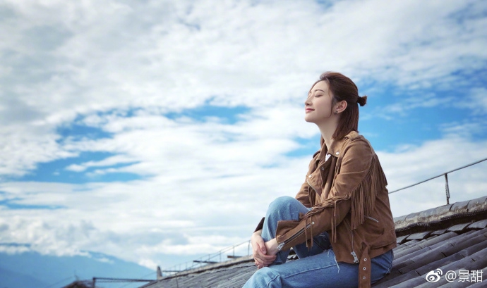 景甜悠闲坐在屋顶晒太阳 半丸子头牛仔裤青春十足