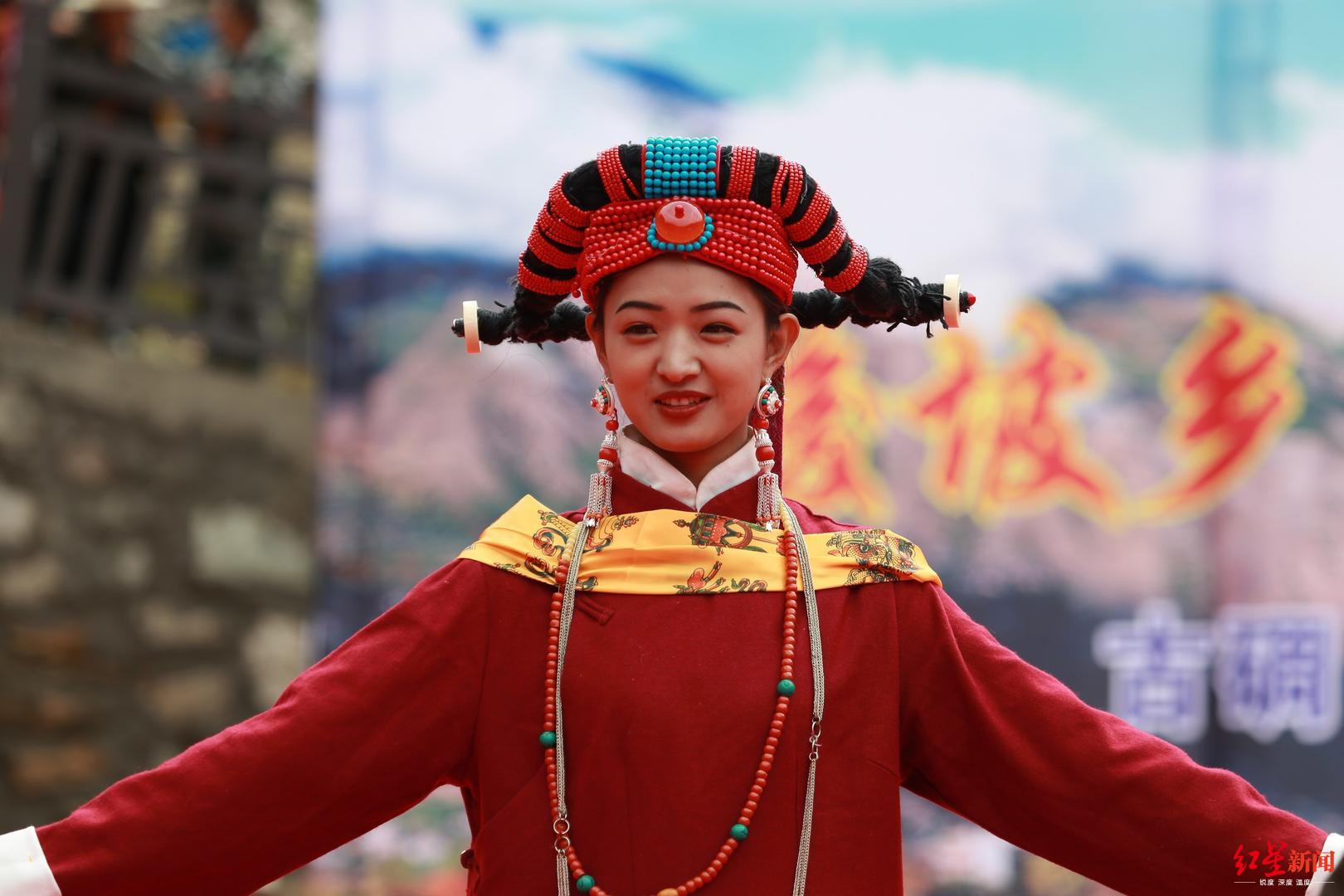 一位位身着嘉绒藏族服饰的姑娘低着头,缓缓走上来,随着祝福声响起,台