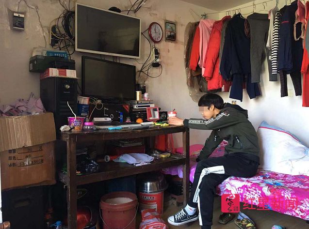 小金在父母租屋里玩手机。图片来源：红星新闻